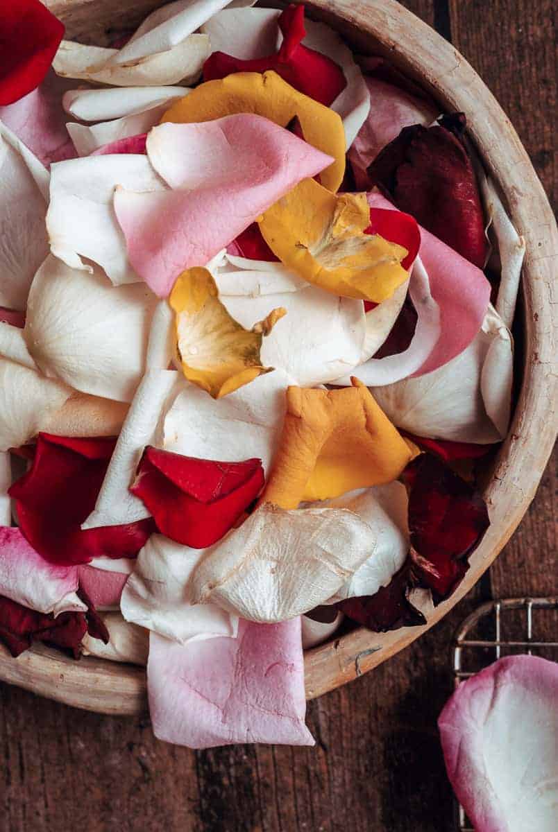 close up shot of colorful rose petals in a ceramic bowl