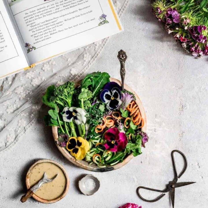overhead shot of vibrant garden pansy salad - greens in a bowl garnished with edible pansies