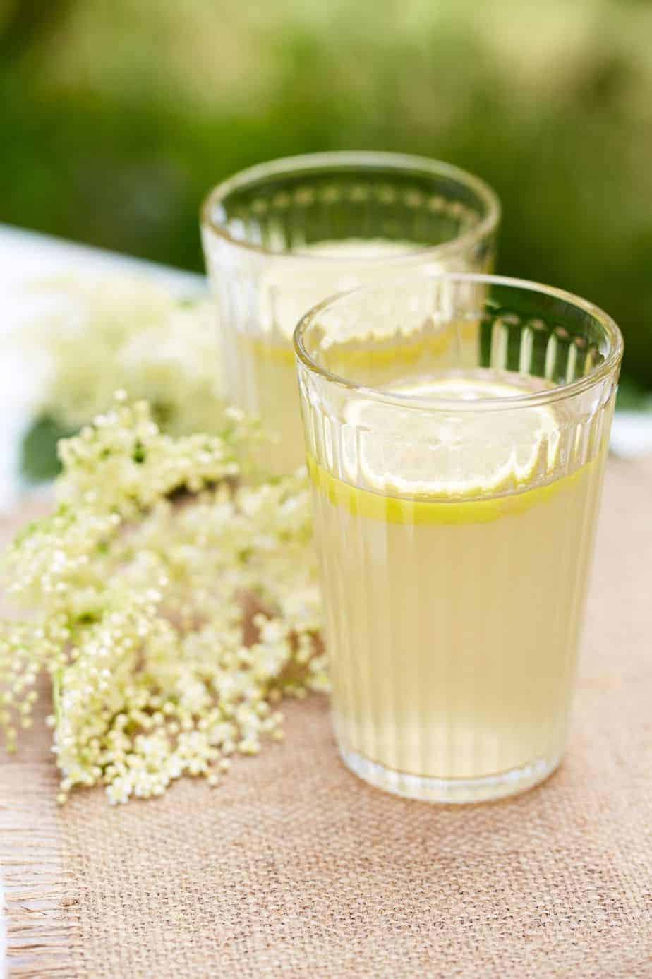 tall glass of lemonade next to some white dainty elderflowers