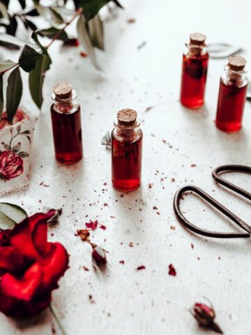 four small bottles of vibrant red rose simple syrup