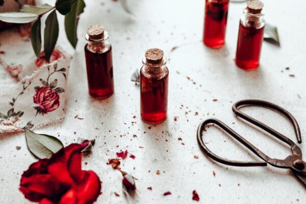 four small bottles of vibrant red rose simple syrup
