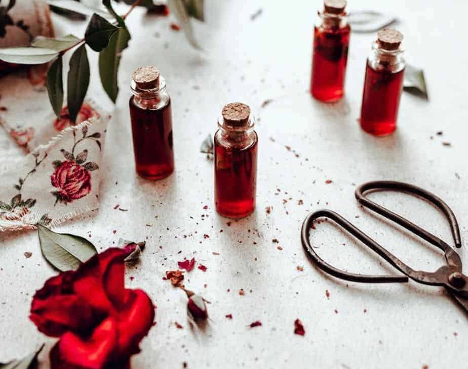four small bottles of vibrant red rose simple syrup