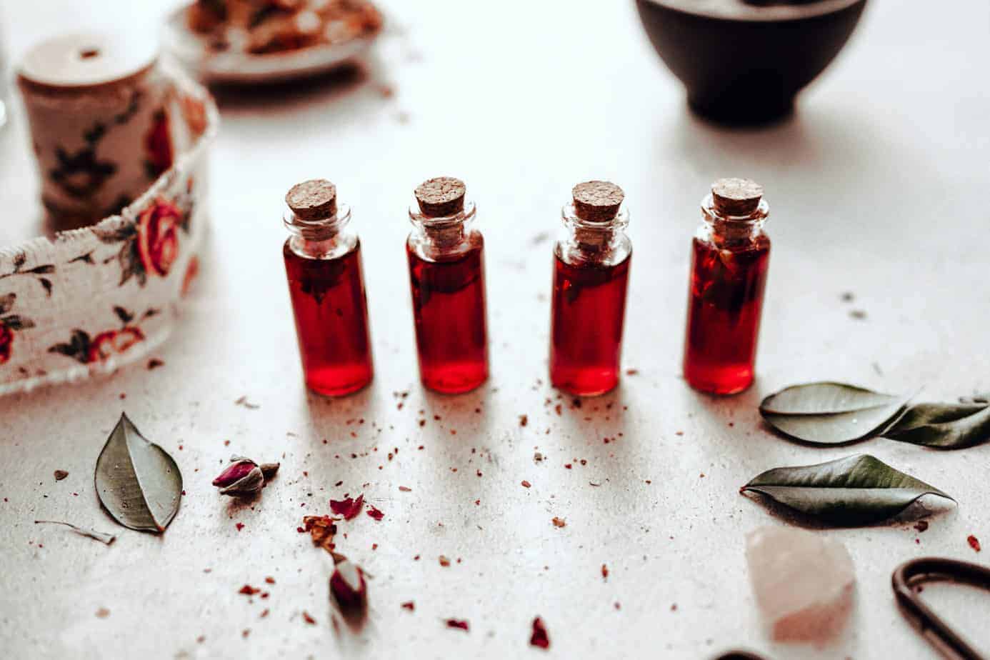 four bottles of rose simple syrup lined up next to eachother