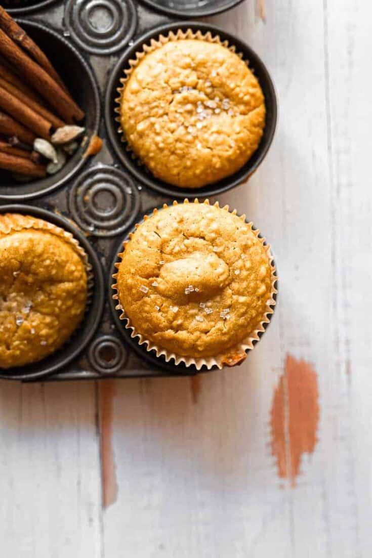 overhead shot of steel cut oat pumpkin muffins in vintage rustic muffin tin, only showing one muffin in focus