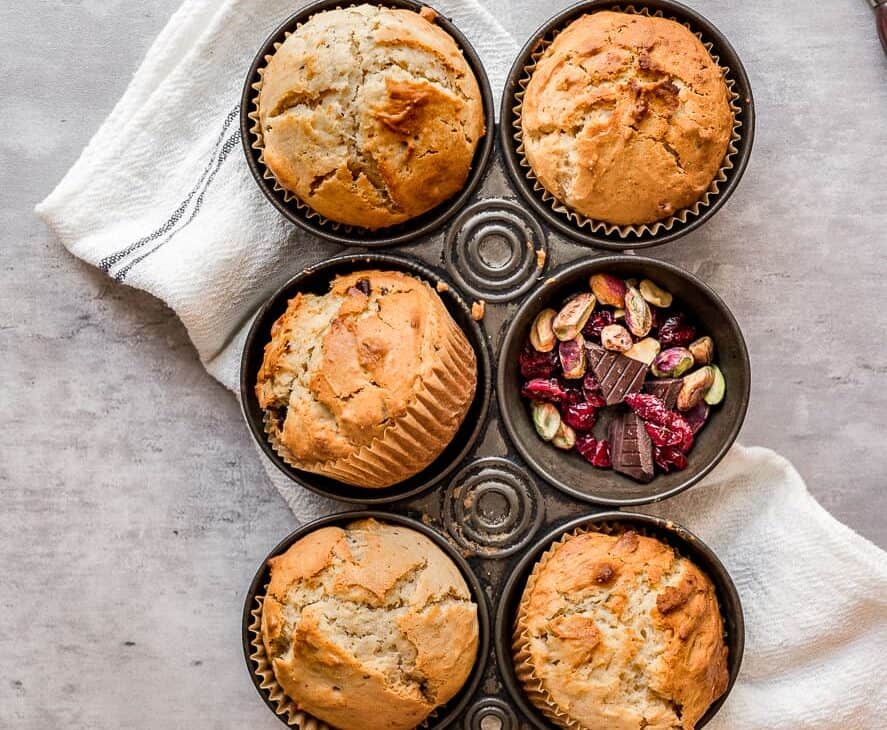 overhead shot of cranberry chocolate pistachio muffins in a vintage baking tin