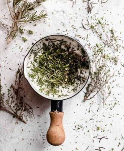 overhead shot of dried rosemary and sugar in a saucepan