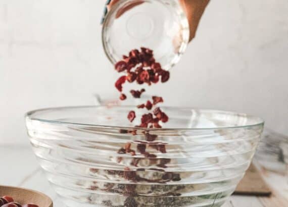 image of cranberries being dumped into a large glass bowl