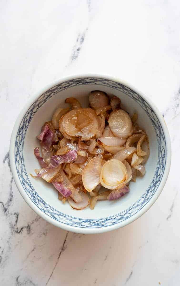 overhead shot of onions and apple in a bowl