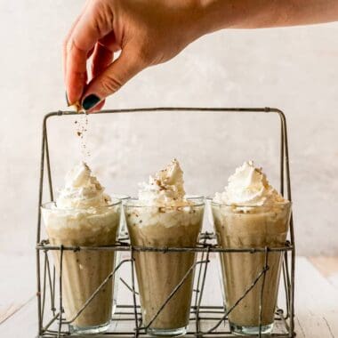 classic creamy eggnog with whipped cream sprinkling nutmeg on top