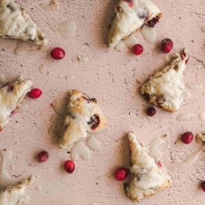 overhead shot of a pink surface with glazed cranberry ginger scones