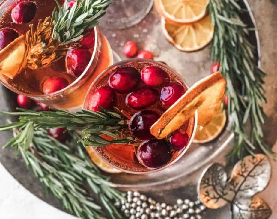 overhead shot of Christmas morning mimosa, with cranberries and fresh rosemary and dried orange