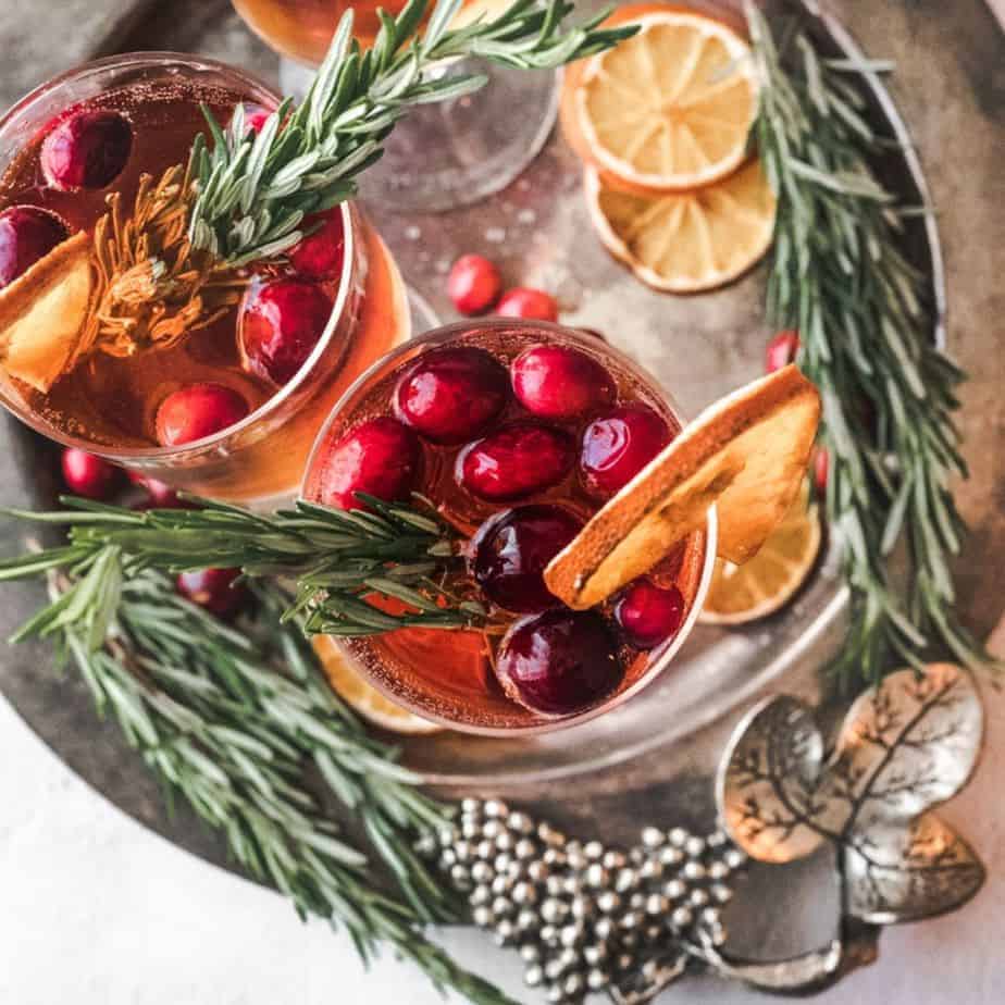 overhead shot of Christmas morning mimosa, with cranberries and fresh rosemary and dried orange