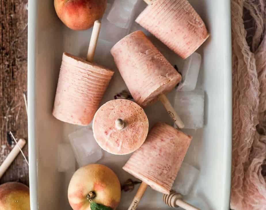 peaches and cream peach colored popsicles in a baking dish, styled in different directions cover