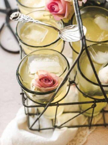 close up shot of glasses of rose lemonade over a vintage handkerchief with roses inside