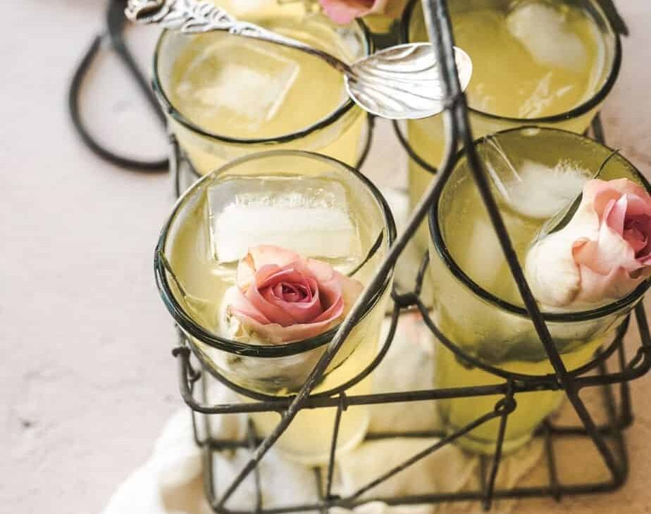 close up shot of glasses of rose lemonade over a vintage handkerchief with roses inside