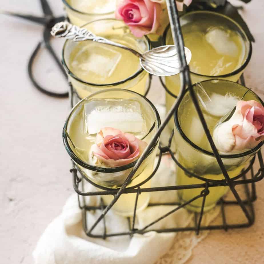 close up shot of glasses of rose lemonade over a vintage handkerchief with roses inside