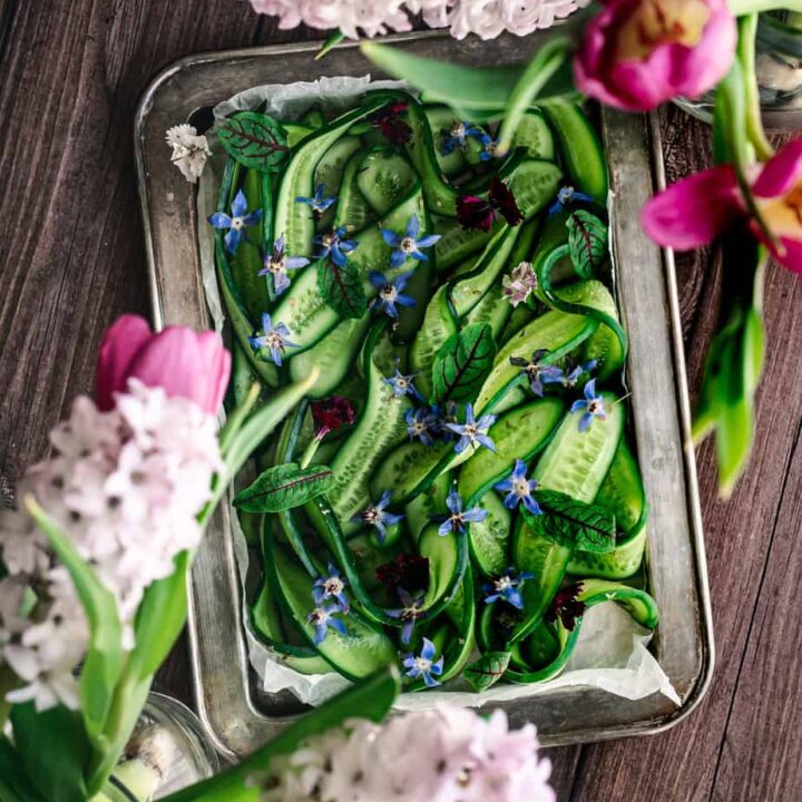 overhead shot of vintage tray with sliced cucumber and borage flowers