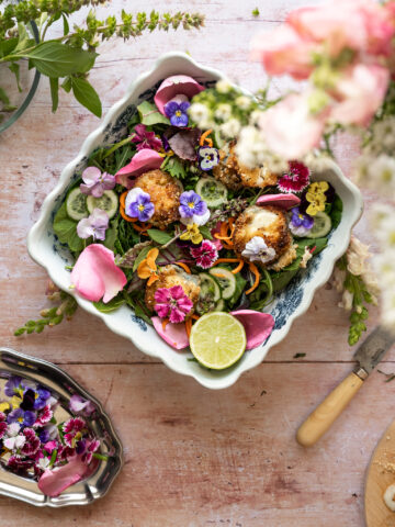 overhead image of bowl of greens filled with fresh organic flowers