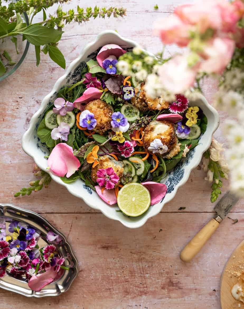 overhead image of bowl of greens filled with fresh organic flowers