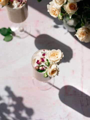 overhead image of a rose latte in elegant glass with harsh light, projecting shadows
