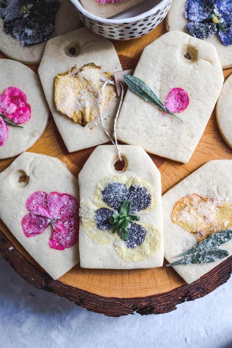 cake stand with light colored sugar cookies with color pansies coated in sugar