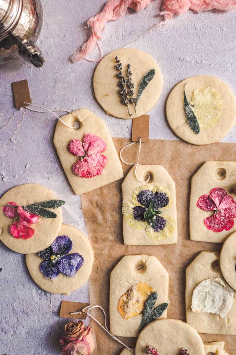 close up tea bag shaped cookies with candied flower petal pressed into them