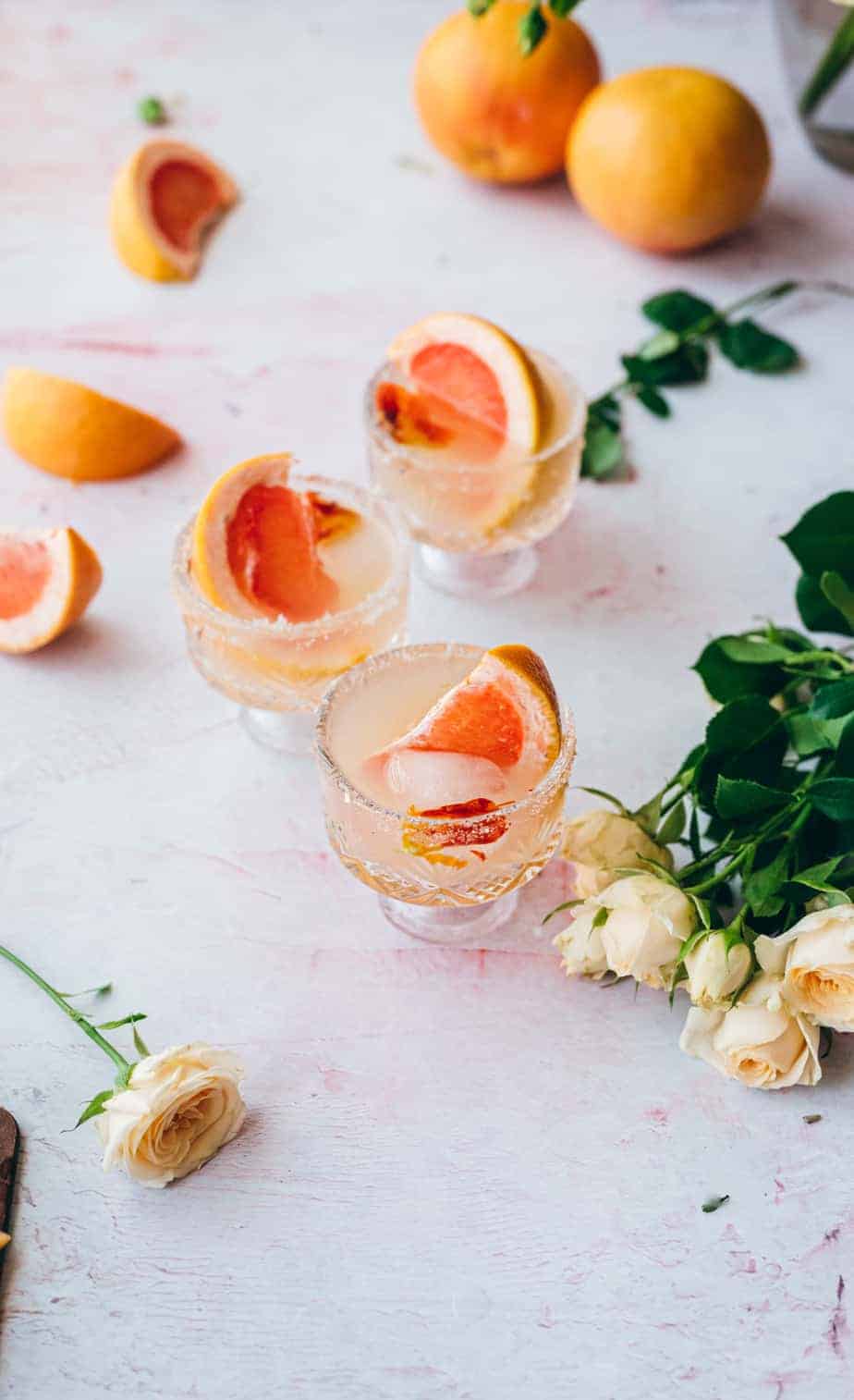 overhead shot of three Dublin glasses filled with grapefruit juice cocktail garnished with grapefruit