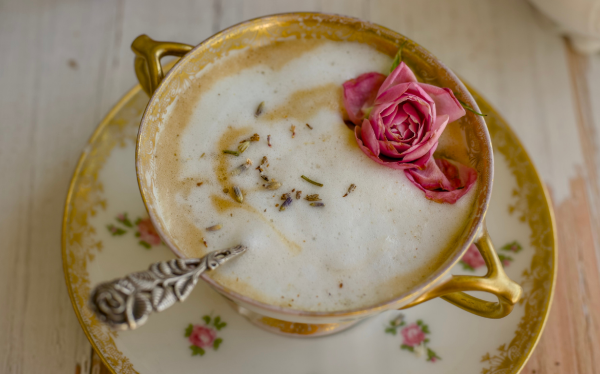 vintage tea cup with lavender latte in front of bouquet of flowers