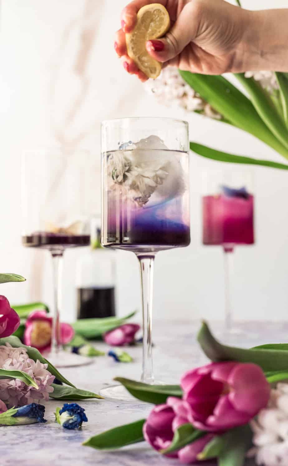 beautiful scene with three tall stem glasses with butterfly pea flower syrup changing from vibrant blue to pink