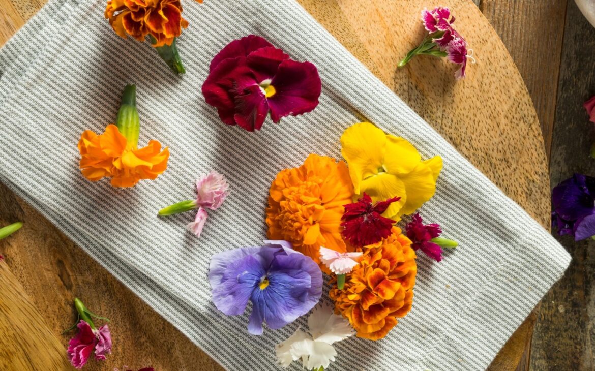 display of edible flowers on a charcuterie board next to a pair of scissors