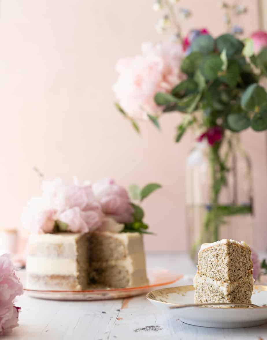 slice of cake cut out of earl grey cake on plate with vase with flowers in background