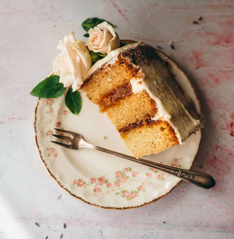 slice of cake on a plate filled with jam topped with flowers