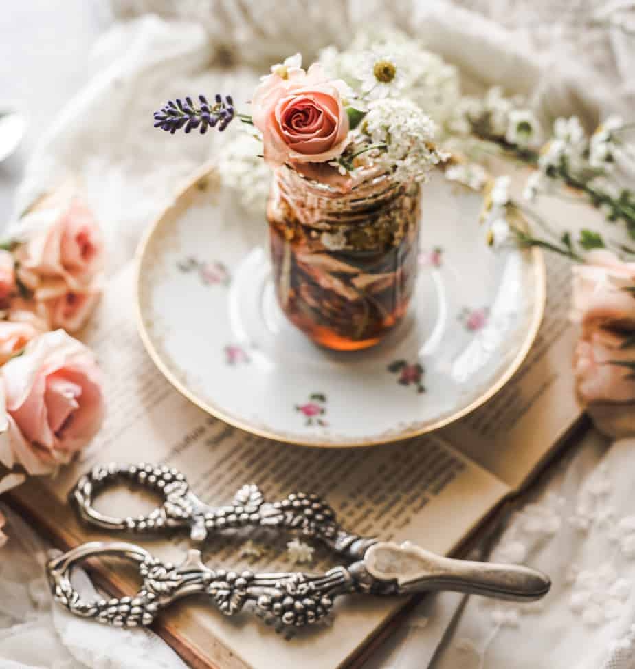 close up bottle of honey filled with flowers 