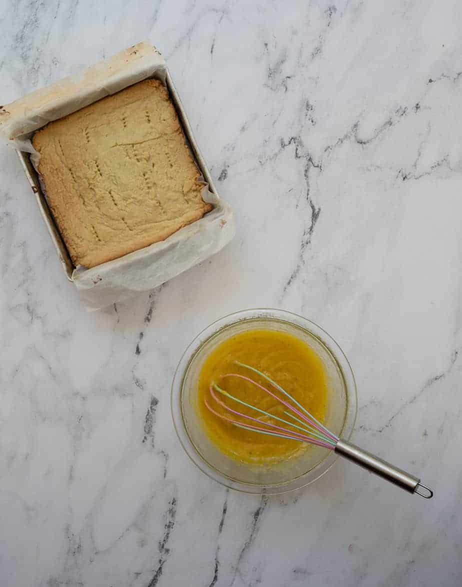 process shot baked shortbread in a small pan next to rosemary lemon curd in a medium bowl with whisk