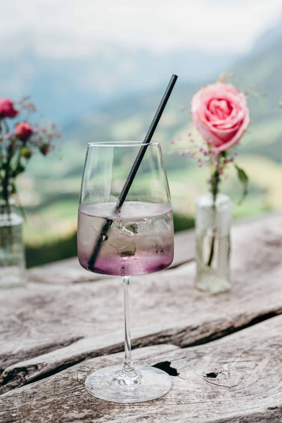 lavender spritz drink in fancy cocktail glass with gorgeous mountain backdrop
