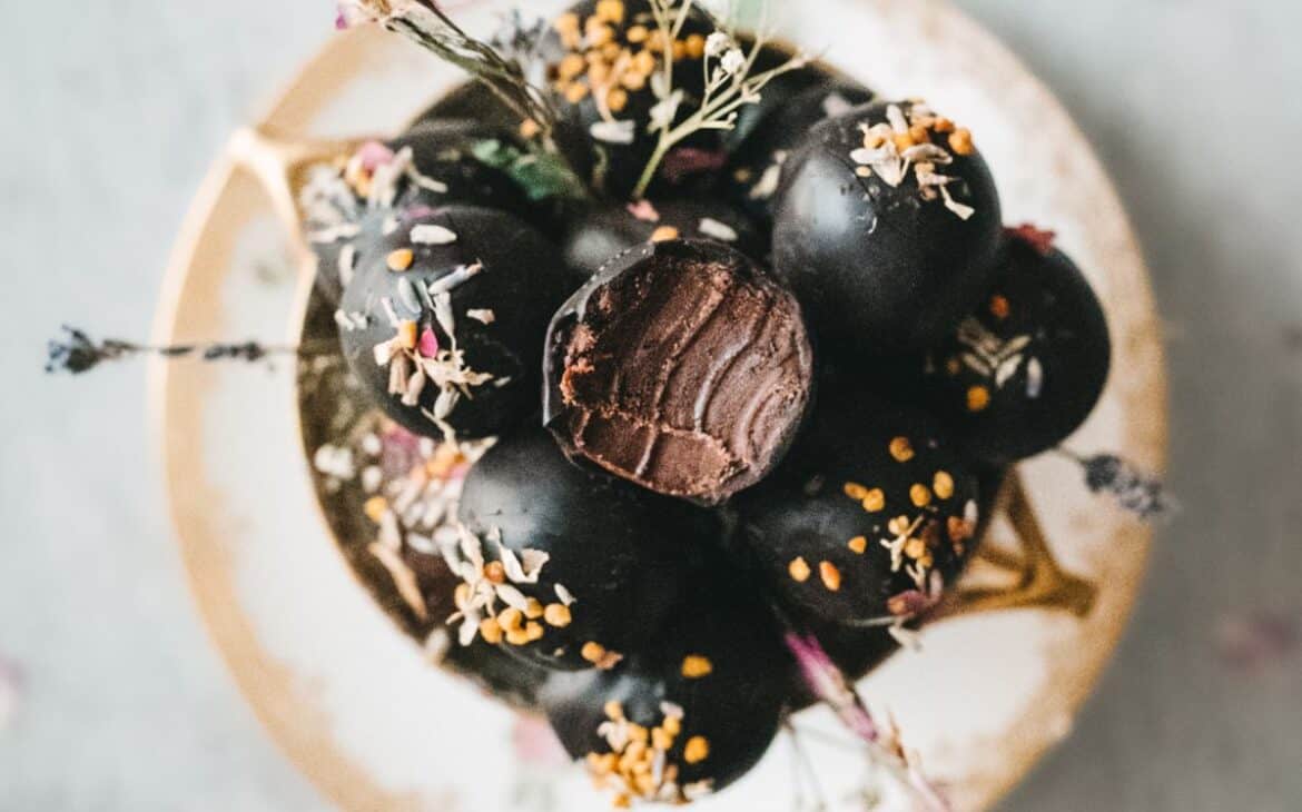 overhead shot of a vintage tea cup filled with lavender chocolate truffles sprinkled with edible flowers