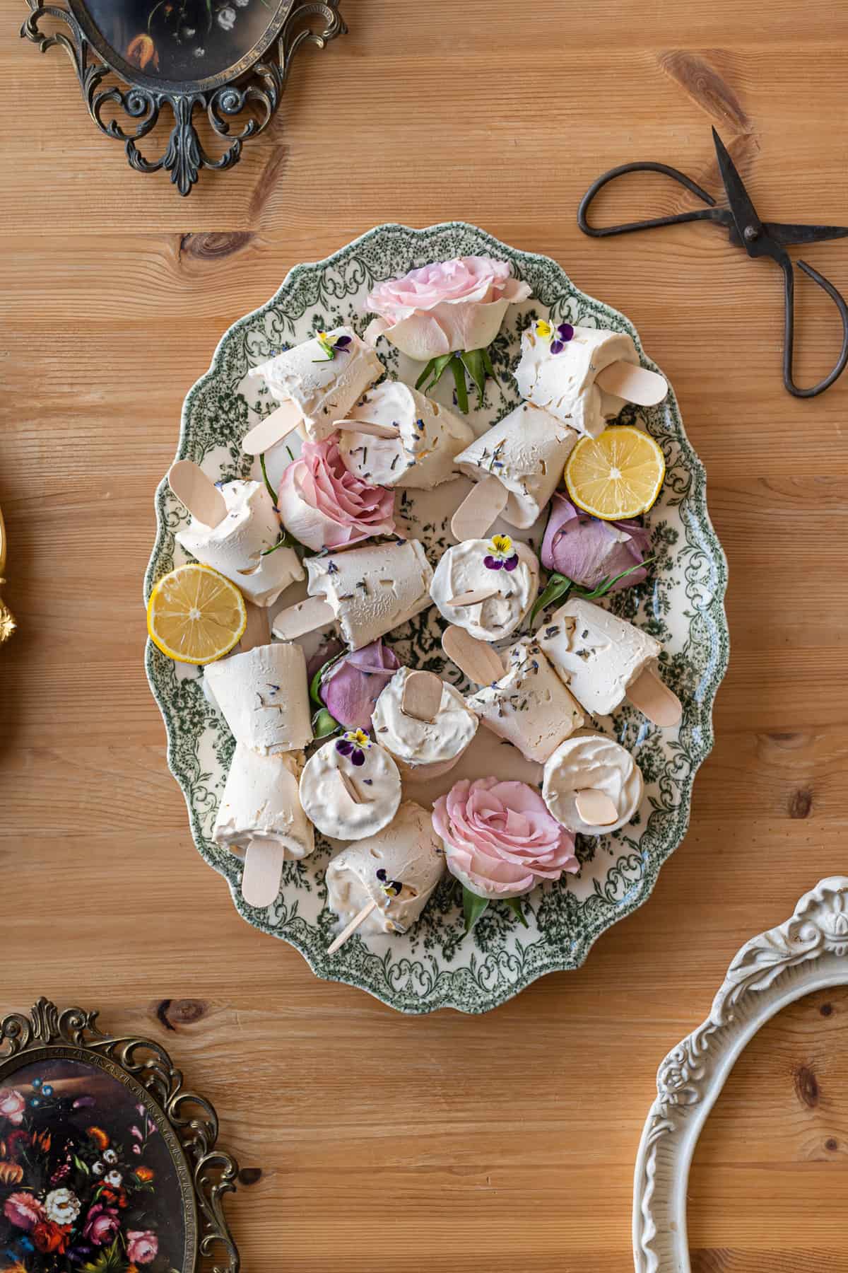 overhead shot of vintage victorian dish filled with lavender lemon ice cream sticks and sliced lemons and roses