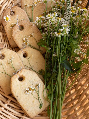 image of tea shaped shortbread cookies in a basket with chamomile flowers