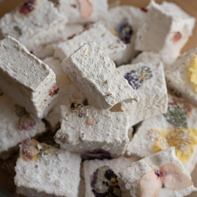 close up image of homemade marshmallow root marshmallows garnished with edible flowers