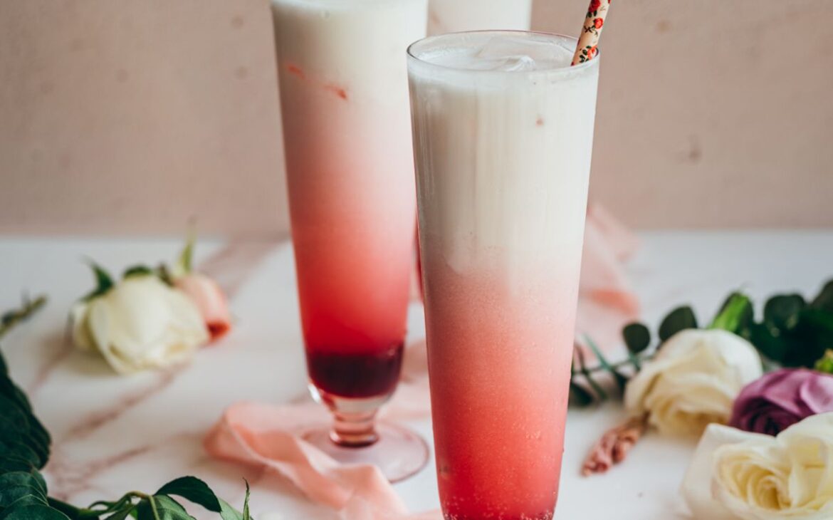 close up image of three tall glasses filled with hibiscus syrup, sparkling water and cream for hibiscus italiann soda