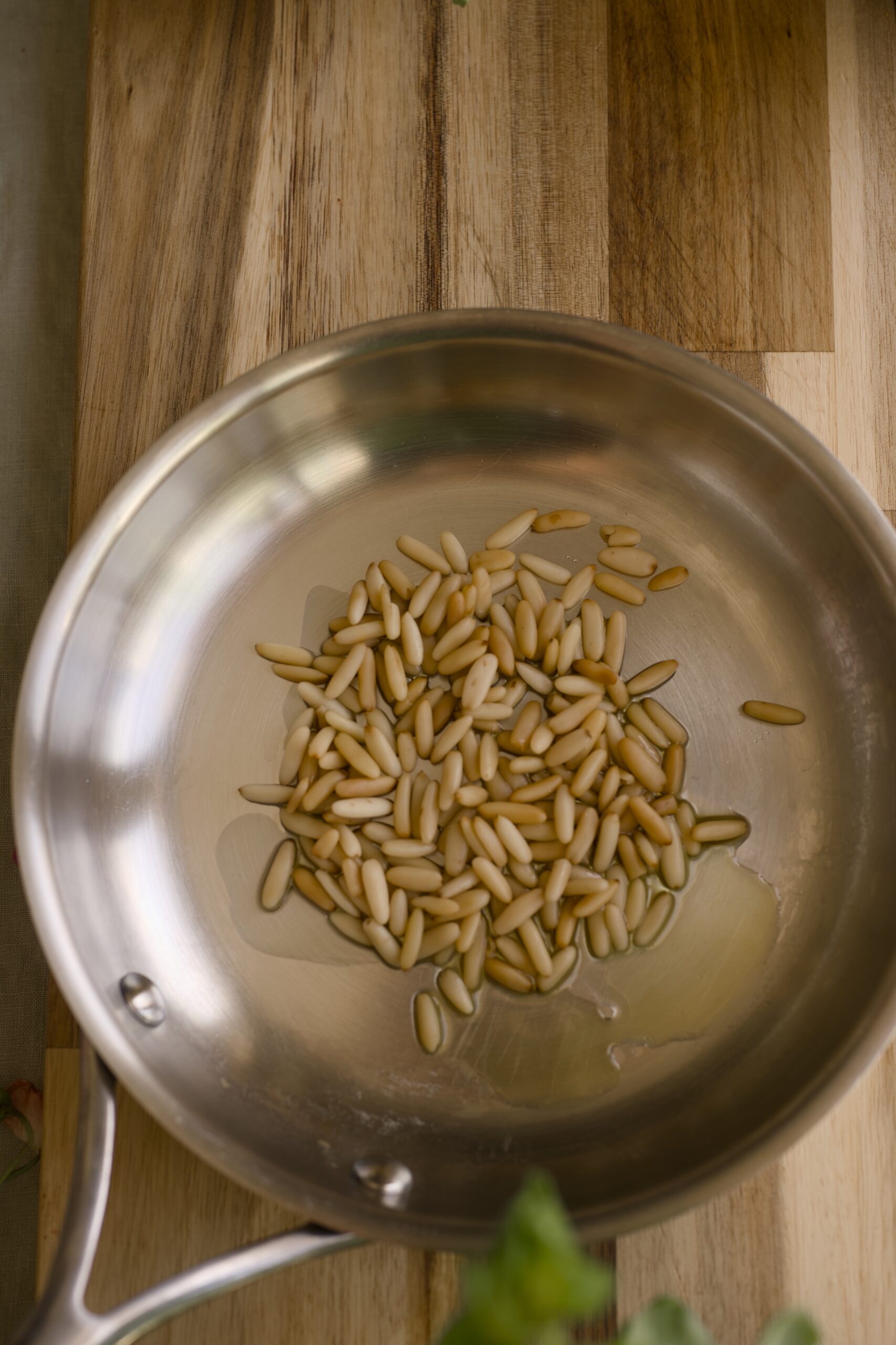 pan with pine nuts for roasting for dandelion greens pesto