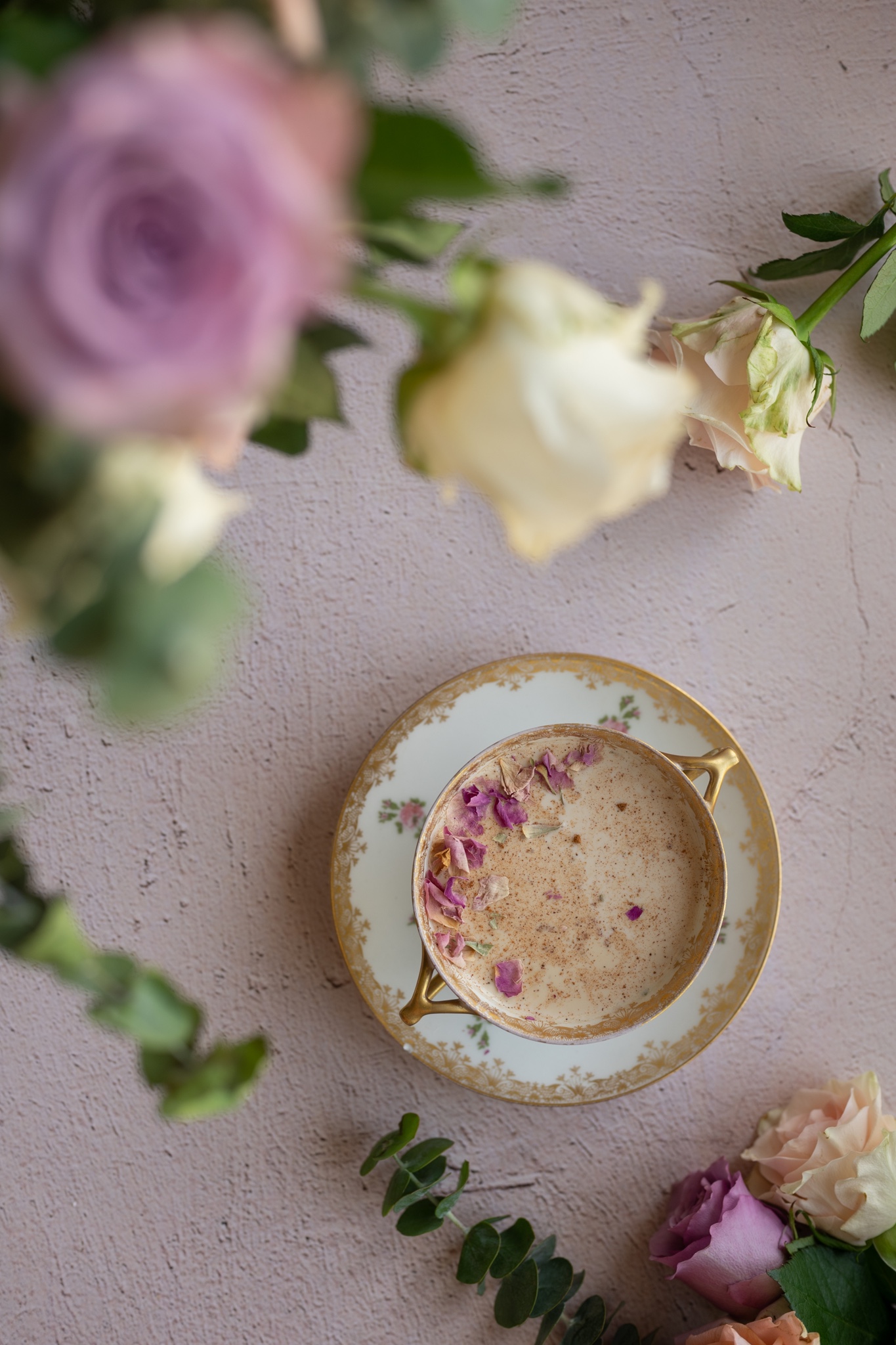 CLOSE UP OVERHEAD IMAGE OF VINTAGE ROSE cup with rose moon milk inside