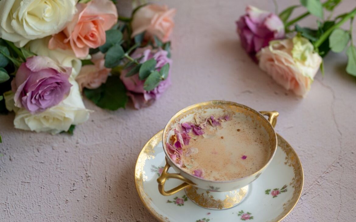 vintage cup with dainty roses filled with rose moon milk surrounded by rose bouquet