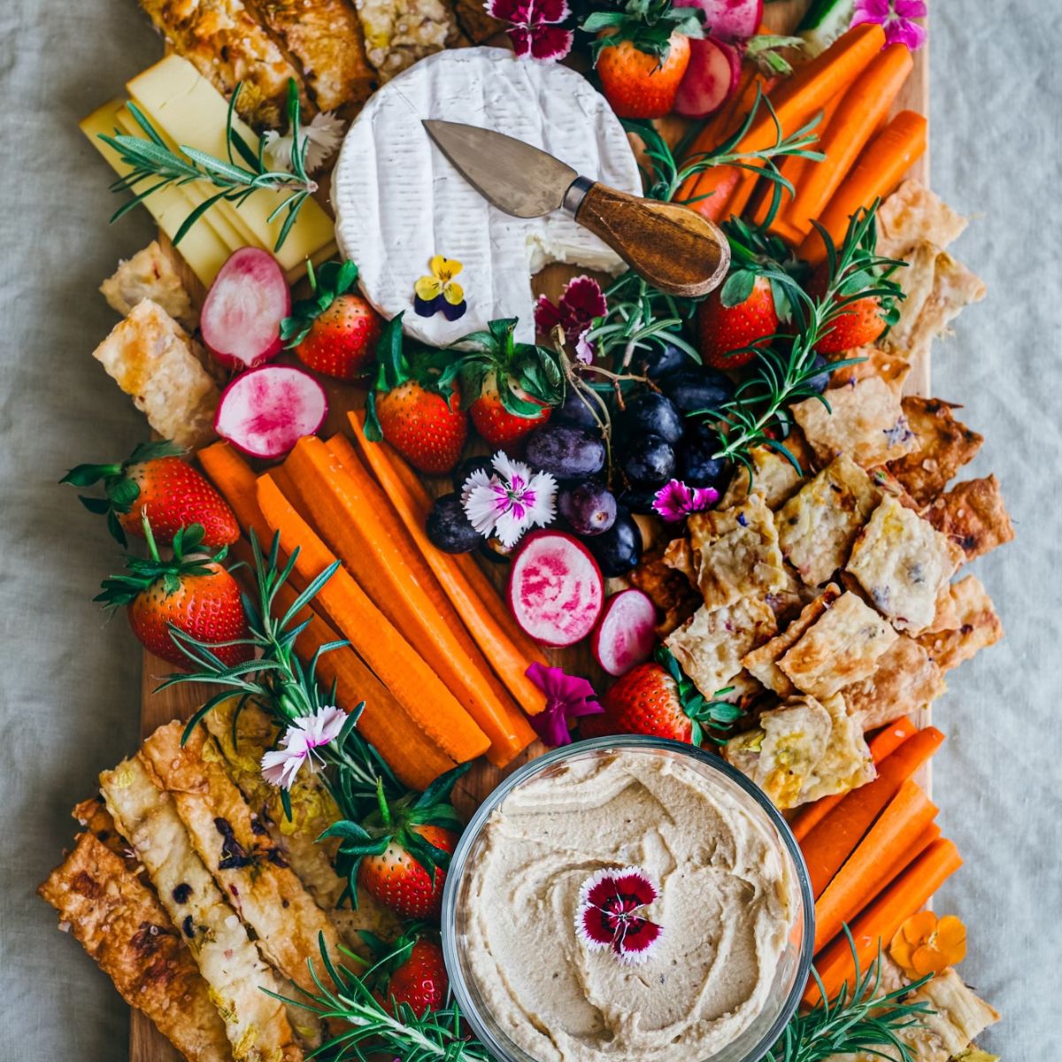 edible flower crackers on a big veggie charcuterie board